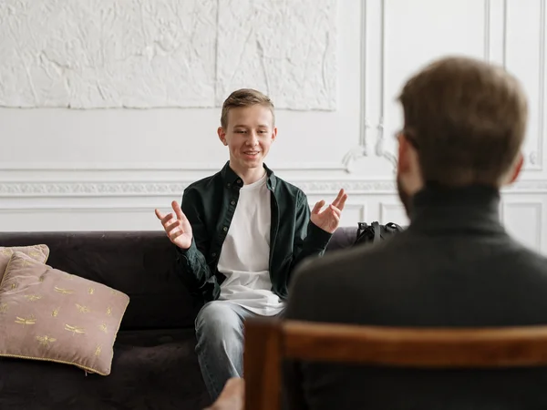 The picture is a stock photo. It shows a young person in a counselling situation with an adult. 
