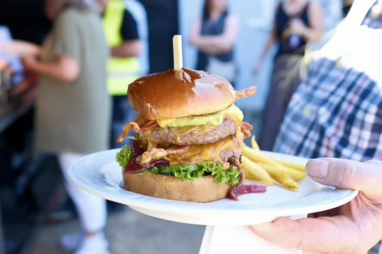 A plate with a large burger on it. 