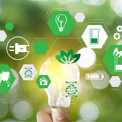 Das Bild zeigt eine Hand, die eine leuchtende Glühbirne hält, während im Hintergrund eine unscharfe grüne Naturkulisse zu sehen ist. Rund um die Glühbirne schweben zahlreiche digitale, grüne Symbole, die Nachhaltigkeit, Umweltschutz und erneuerbare Energien repräsentieren. Dazu gehören Symbole wie das Recycling-Zeichen, ein Blatt für Ökologie, ein Globus, ein Haus mit einem Blatt, Batterien, DNA-Strukturen, Zahnräder und Symbole für erneuerbare Energie wie ein Stecker und eine Glühbirne. Die grüne Farbgebung und die natürlichen Elemente des Bildes vermitteln eine Botschaft von Innovation, Umweltschutz und nachhaltigen Lösungen.