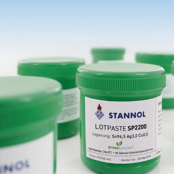 The picture shows several green cans of solder paste from Stannol. They bear a white label with the Stannol logo and the product designation SP2200.
