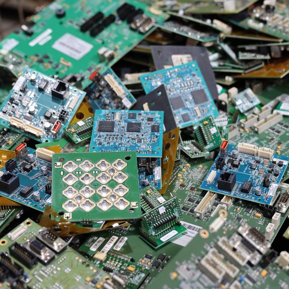 Stapel ausgedienter Leiterplatten in verschiedenen Größen und Farben.