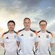 The picture shows Iljan Sandtstedt, Thomas Kolossa and Nicolas Wiacker in Germany football shirts. They have their arms crossed behind their backs and are smiling friendly into the camera.