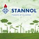 The picture shows the logo and branding of the company "Stannol" with the slogan "Pioneers of Soldering". The Stannol logo is at the top left and consists of a diamond with the company name in it and a red flame at the top, symbolising the soldering process.  The background combines two themes: Technology and Sustainability. The upper part shows a blurred close-up of an electronic circuit board, emphasising Stannol's connection to the electronics industry. The lower part shows a green landscape with various elements symbolising sustainability. These include wind turbines, factories and trees, all designed from plant textures such as leaves or grass. Hovering above them are cloud-like shapes made of green foliage.  The image combines Stannol's technical expertise with a commitment to environmentally conscious practices.