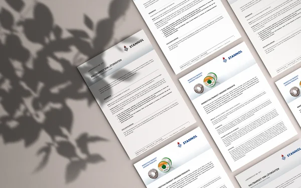 Mehrere Dokumente auf einem Tisch, daneben Schatten von Pflanzen.