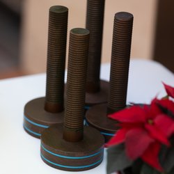 Auf dem Bild sind vier Awards zu sehen, eine Art große, hölzerne Schraube. Im Vordergrund ist im Anschnitt ein roter Christstern zu erkennen.