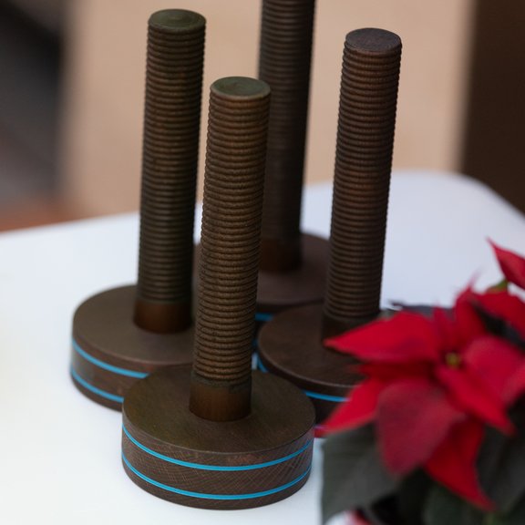 The picture shows four awards on a table: A kind of large, wooden screw standing on its head. A red Christmas star can be seen in the front.