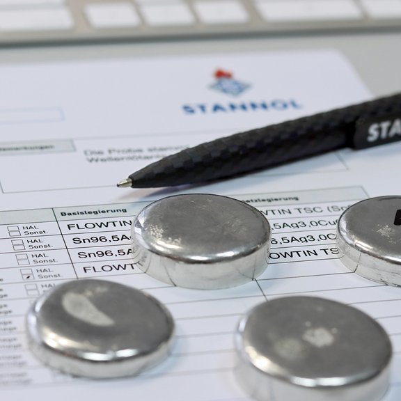 Dokument, Metallobjekte und Stift auf einem Schreibtisch.