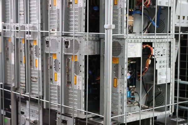 Serverraum mit mehreren gestapelten Computereinheiten hinter einem Gitter.