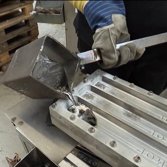 Auf dem Bild ist eine Gussform zu sehen, in die flüssiges Lot gefüllt wird.