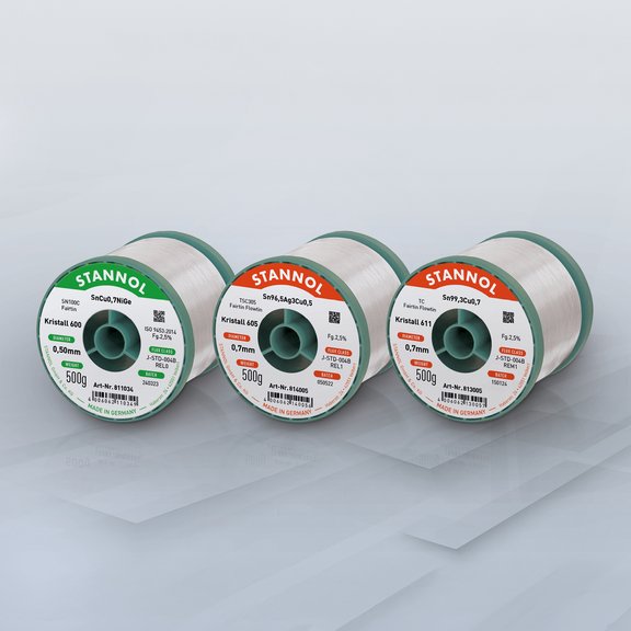  Three spools of solder wire side by side on a grey background.