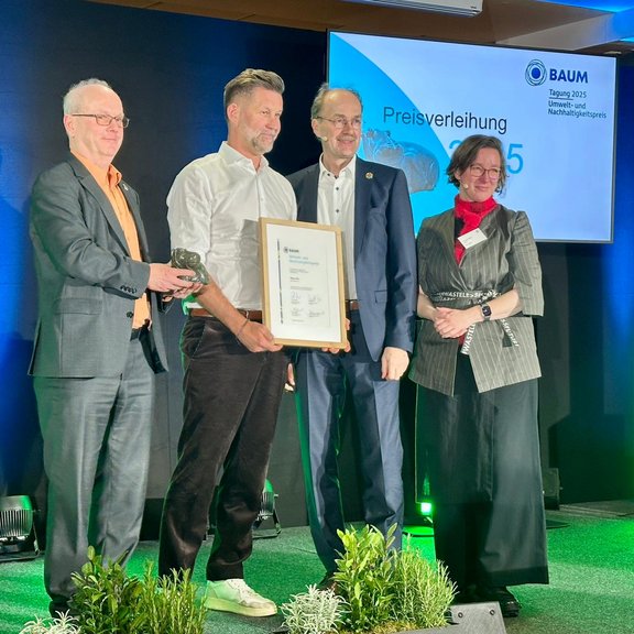 Four people on stage at an awards ceremony.