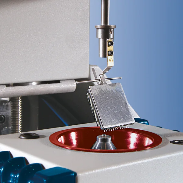 The picture shows the wetting scale from GEN3 Systems. A component is mounted in a holder and is slowly lowered onto a small solder ball.