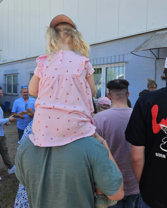 A little girl sitting on a man’s shoulders.