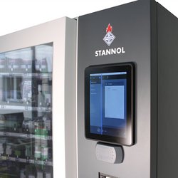 Auf dem Bild ist ein Ausschnitt des Smart Warehouses von Stannol zu sehen: Ein großer Automat mit Sichtfesnter links und einem Display auf der rechten Seite. Über dem Display ist das Stannol-Logo zu erkennen.