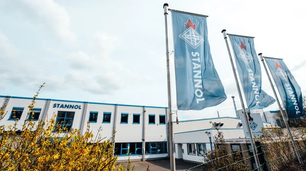 Stannol building with three Stannol flags flying, against a blue sky in the background.