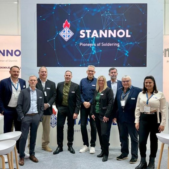 Group of people in front of a Stannol company exhibition booth.