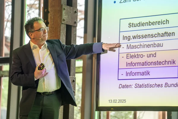 Redner zeigt auf eine Präsenation