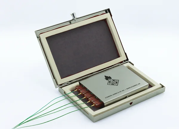 The picture shows the Thermologger 5000 from Stannol, a temperature profile measuring device. The device is about the size of a laptop, has a metal housing and five temperature sensors on the side.