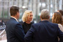 Auf dem Bild ist eine Gruppe von vier Personen zu sehen, die sich unterhalten.