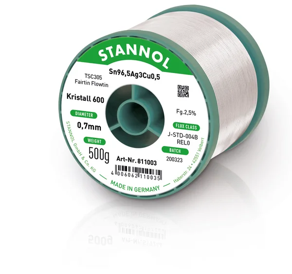 The picture shows a horizontal Kristall 600 solder wire reel. The label on the front is green and white and bears various product specifications and the Stannol logo.